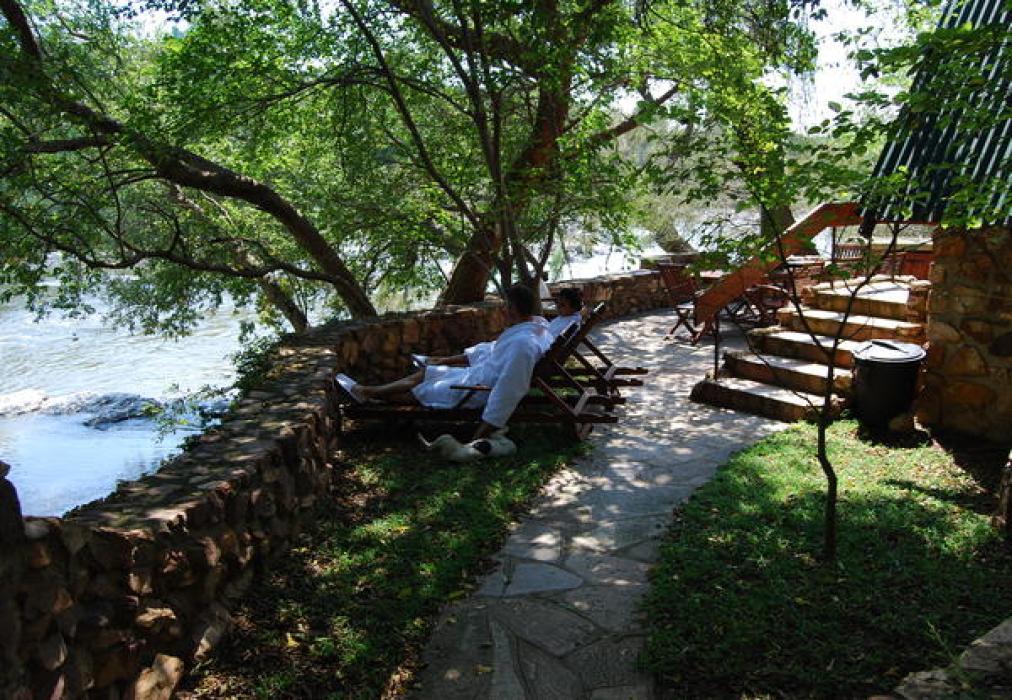Ibis River Retreat — riverside loungers under indigenous trees